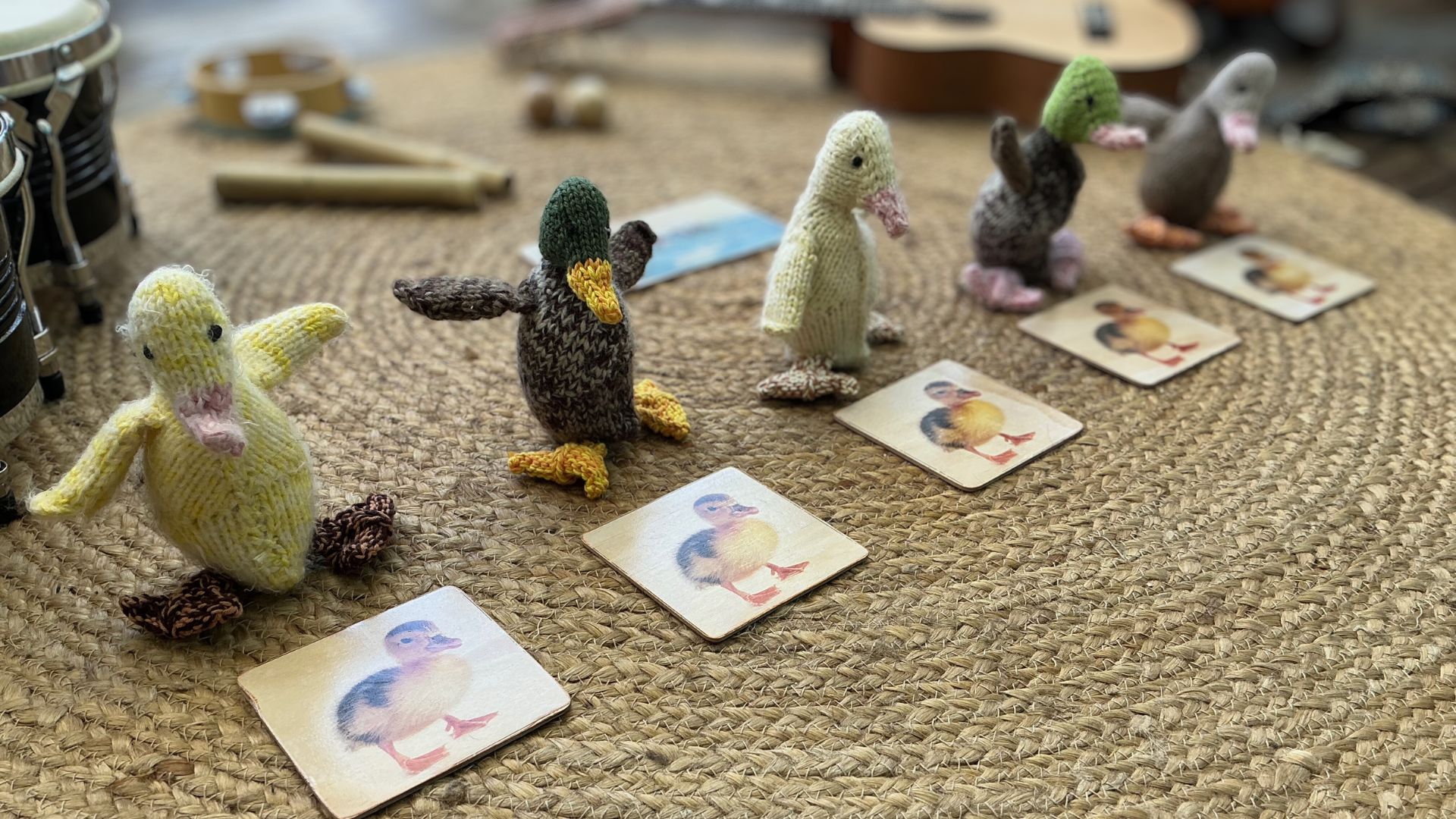 Five little ducks song materials laid out with ducks, song card and percussion instruments
